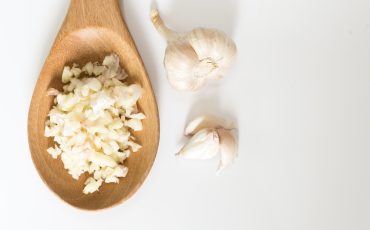 Wooden,Spoon,Of,Chopped,Garlic,With,White,Background.,Minced,Garlic
