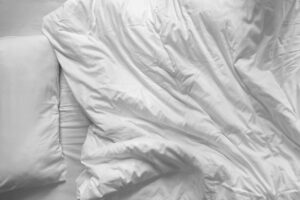 Top,View,Of,Unmade,Bedding,Blanket,And,Pillow,Or,White