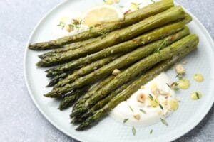 Tasty,Cooked,Asparagus,Served,With,Lemon,And,Sauce,On,Grey Tasty,Cooked,Asparagus,Served,With,Lemon,And,Sauce,On,Grey